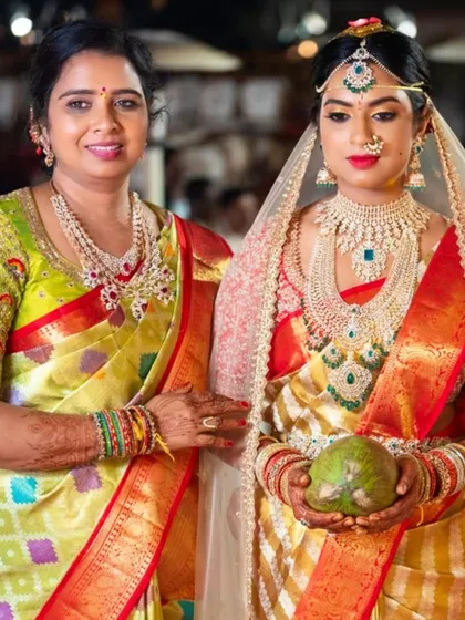 A beautiful portrait of a mother and her daughter, the bride. The mother's lime green blouse is custom-designed with intricate embroidery to complement her saree.