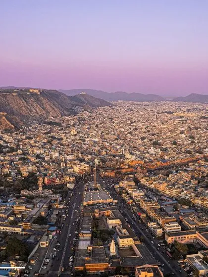 The Pink City, Jaipur, seen from above at dusk. The aerial perspective shows the vastness of the city against the backdrop of the Aravalli hills.