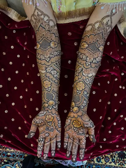 Another shot of Mariam's mehendi against a rich red velvet background.