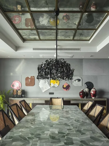 The dining room at 'The 42, Kolkata' project, featuring a custom dining table made from light green aventurine stone. We paired it with our own cane-woven chairs and a dramatic Brand van Egmond chandelier to create a space that balances raw materiality with refined elegance.