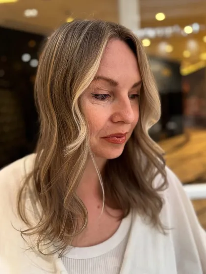 The side view of this pearl blond balayage shows the seamless blend from roots to ends.