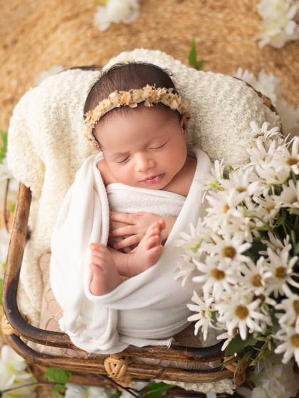 A classic basket pose, elevated by the addition of fresh white daisies. The natural wood, cream fabrics, and flowers create a beautiful, organic feel.
