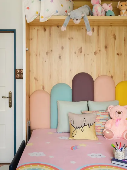 The kids' room is a playful space following an RGB theme with pastel shades. The Murphy bed, which transforms from a couch to a bed, is a smart solution that maximizes play space for the girls.
