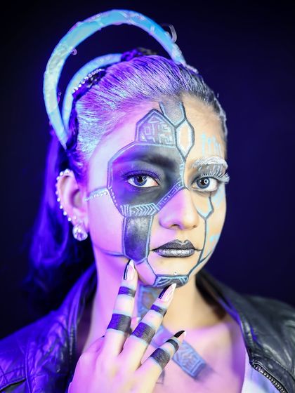 A cyberpunk-inspired look with half-face robotic makeup and a glowing headband.