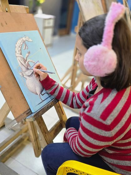 Another view of our young student working on her surreal giraffe illustration. Our kids' classes often explore fun and fantastical subjects.
