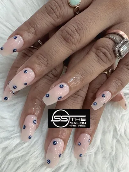Keep your style on-trend with our popular evil-eye nail art. This design features the iconic symbol meticulously painted on a neutral, coffin-shaped nail extension for a chic and protective statement.