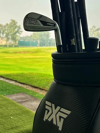 A full bag of performance. A brand new set of PXG irons sits in a sleek cart bag, overlooking the driving range from our fitting bay.