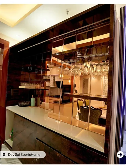 For the entertainer, a custom bar unit is a must. This piece features a rich wood finish, mirrored backsplash to create a sense of space, and integrated glass hangers, making it a sophisticated focal point for any gathering.