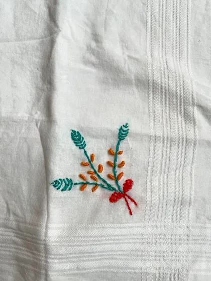 A small, delicate bouquet embroidered on a handkerchief by my 11-year-old student. It is heartwarming to see the next generation embrace this craft.