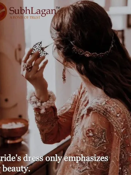 A bride in a beautiful peach-colored outfit looks at herself in a hand mirror. We celebrate the confidence and beauty of the women in the Agrawal, Jain, and Maheshwari communities.