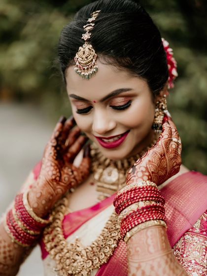A close-up shot of a bride's happy expression, focusing on her beautiful smile and intricate henna.
