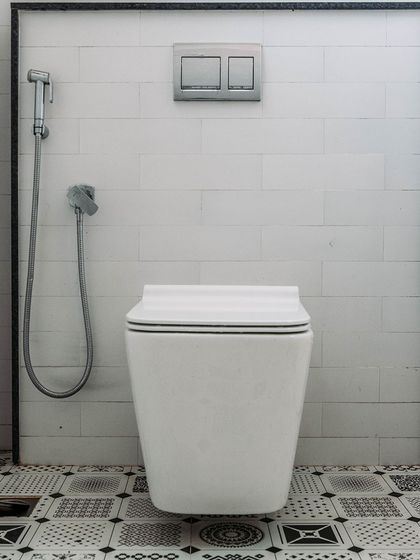 A study in black and white. The geometric pattern of the floor tiles contrasts with the simple white subway tiles on the wall, creating a bold and graphic bathroom design.