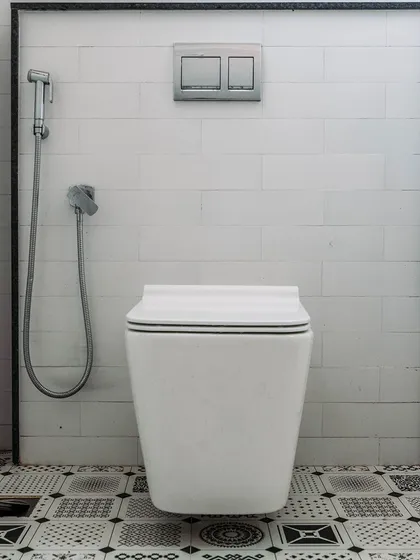 A study in black and white. The geometric pattern of the floor tiles contrasts with the simple white subway tiles on the wall, creating a bold and graphic bathroom design.