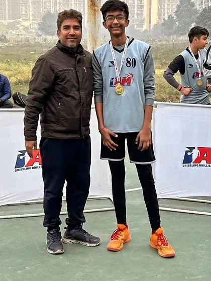 A player posing with his medal. We track progress and reward hard work and improvement.