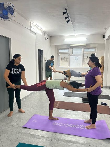 This partner-assisted Warrior III pose helps the student feel the correct alignment and extension without the fear of falling.