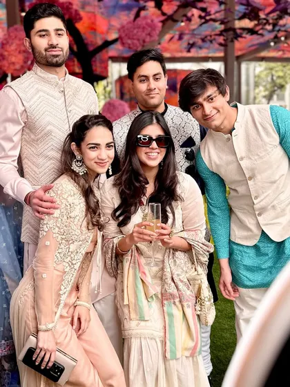 A stylish group of friends enjoying a glass of champagne and posing for a photo. Our booth is a natural gathering spot at any celebration.