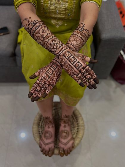 A complete bridal look with intricate mehendi on both hands and feet, ready for the wedding.
