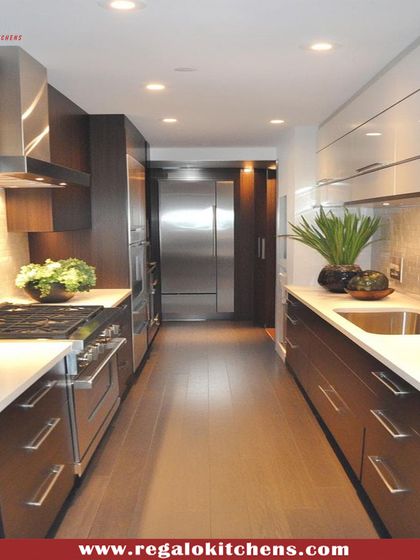 This galley kitchen combines dark wood cabinets with stainless steel appliances for a professional, modern look. The parallel layout is perfect for a streamlined cooking process, with everything you need located within a few steps.