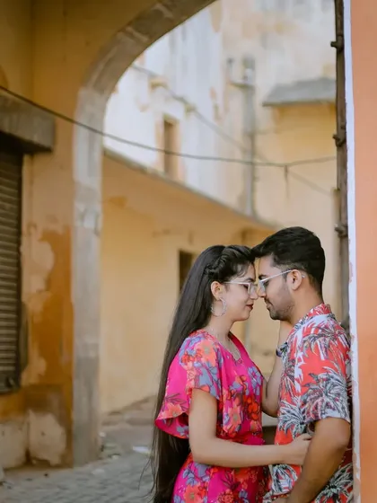 A romantic close-up in a rustic, textured corner of the Pink City. The warm colors of the walls add to the charm of this candid pre-wedding photo.