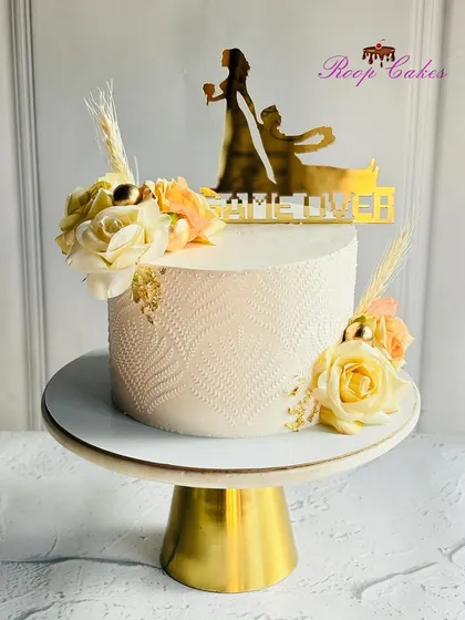 A fun and elegant cake for a bachelorette party. This design features a subtle stencil texture, fresh flowers, and a playful 'Game Over' topper to celebrate the bride-to-be.