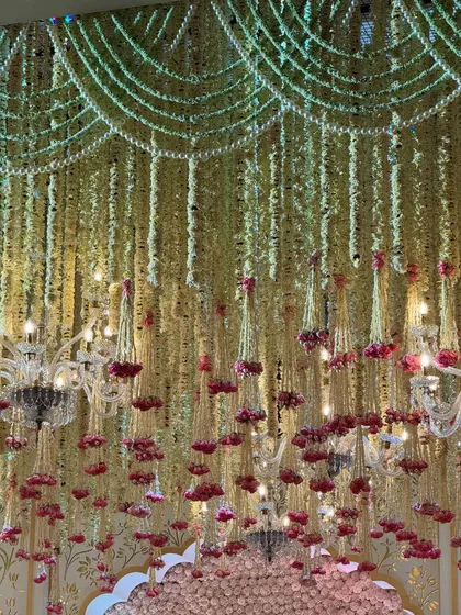 A look up at the symphony of soft blooms and golden accents. The floral ceiling, interspersed with small chandeliers, creates a magical, fairytale-like canopy. 🌸✨