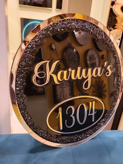 A closer look at the details of the "Kariya's" nameplate, showing the beautiful contrast between the glossy black resin and the sparkling stones.