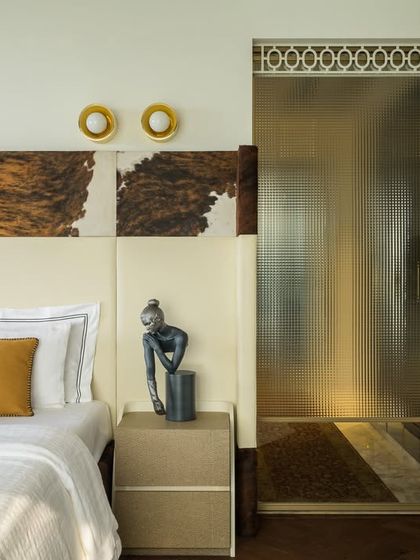 Welcome to the master of all bedrooms, where custom luxury meets quiet drama. In this 2192 sq. ft. space, I used layered textures and obsessive detailing, like the unique hide-patterned headboard, to craft a mood of pure elegance.