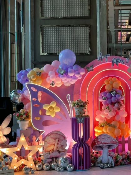 Details of the enchanted party, including a light-up star, a fairy statue, and silver disco balls scattered among the flowers.