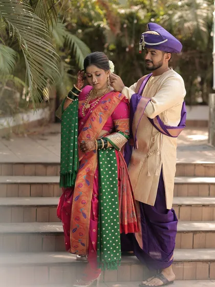 The groom helps the bride with her jewelry, a candid moment filled with love.