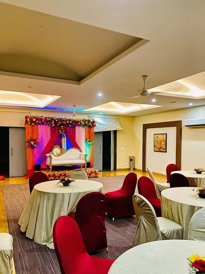 This photo shows how my stage decoration fits into the larger banquet hall. I ensure the stage is the main focus while also providing simple floral centerpieces for the guest tables.