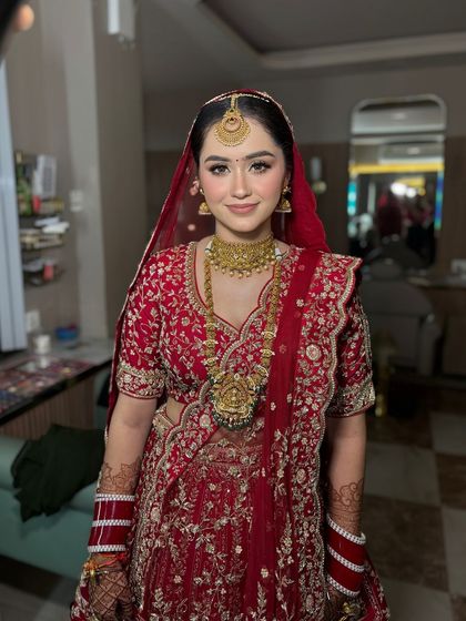 A full view of this stunning bridal lehenga. The makeup was designed to be timeless and elegant, perfectly matching the classic red and gold ensemble.