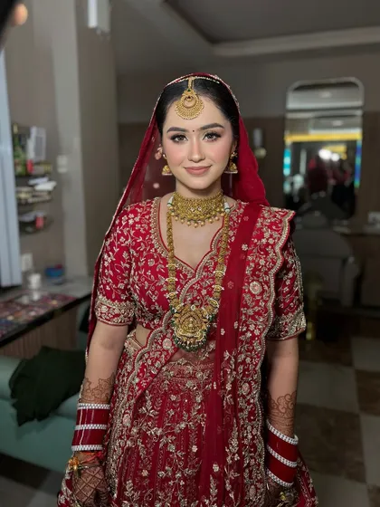 A full view of this stunning bridal lehenga. The makeup was designed to be timeless and elegant, perfectly matching the classic red and gold ensemble.