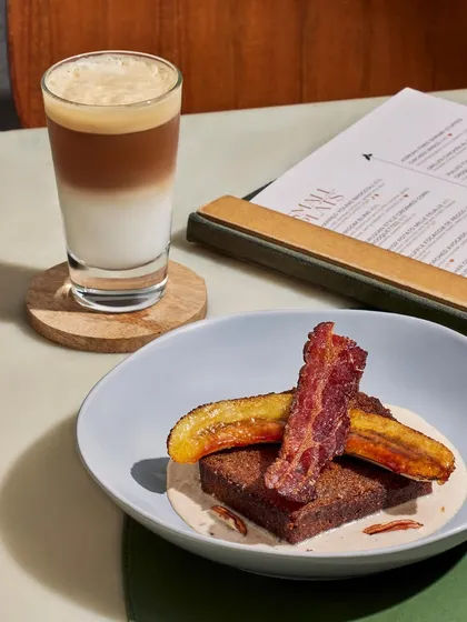 Our Caramelized Banana Bread, served with candied bacon and a rum pecan custard, paired with a layered coffee.