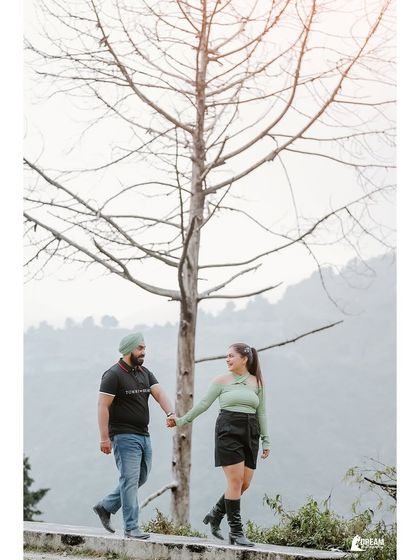 A candid, happy moment of the couple walking hand-in-hand, with the soft light and natural background creating a warm and romantic feel.