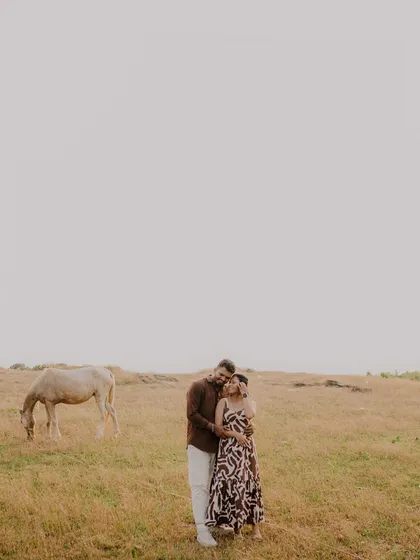 A stunning wide shot that captures the couple in a vast, open landscape. The minimalist composition makes their embrace the central focus of this epic, romantic scene.