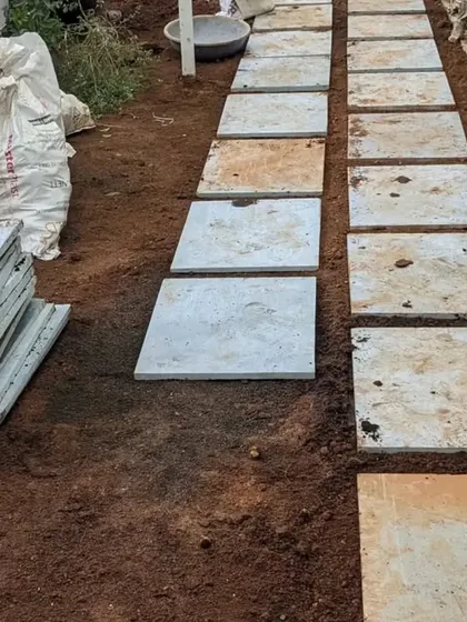 The process of creating the stone pathway. We first lay out the slabs to get the spacing and alignment just right before setting them.
