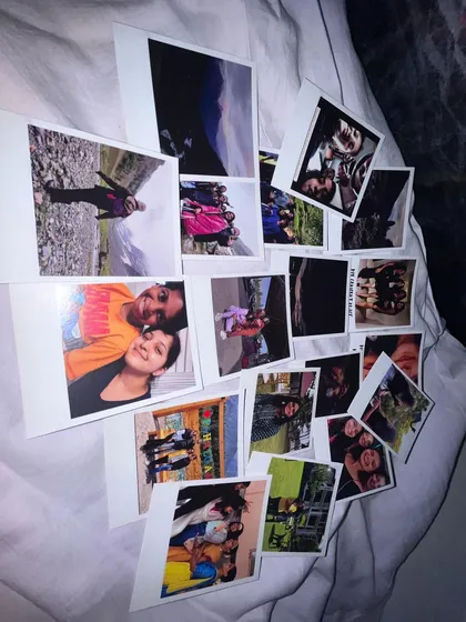 A candid shot of a customer's order, featuring a diverse collection of memories printed as Polaroids, from travel photos to couple portraits.