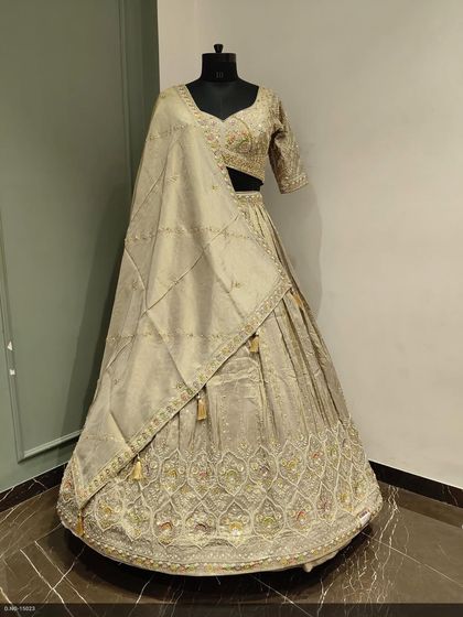 A classic and elegant lehenga in a muted gold tone. The skirt features intricate embroidery all over, making it a sophisticated choice for a wedding reception or engagement.