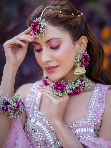 A close-up on the stunning eye makeup and the fresh floral maang tikka.