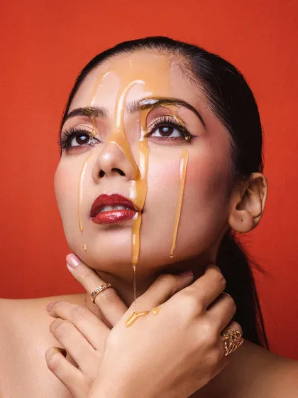 Another angle from our honey drip shoot. This upward gaze adds a sense of drama and artistry to the shot, highlighting the glossy texture of the honey against the skin.