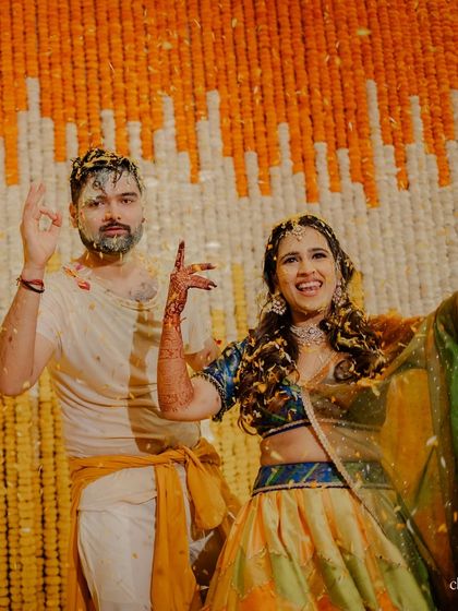 A candid shot of the couple after the Haldi, looking joyfully messy and happy.