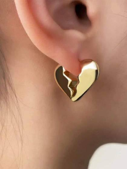 A model shot of the unique broken heart gold plated earrings, a modern and edgy design for a subtle statement.