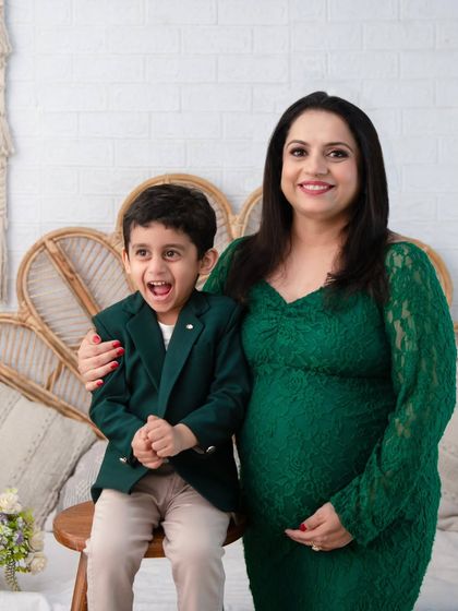 The pure excitement of becoming a big brother. This candid shot captures a moment of genuine joy between mother and son during their maternity photoshoot.