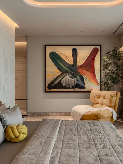 The bedroom in this Shivaji Park home is a cocoon of tactile luxury and quiet indulgence. A bold abstract painting and a plush yellow armchair add pops of color to the otherwise neutral and textured space, creating a refined balance of material, memory, and modern design.