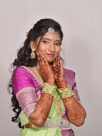 A stunning bride on her wedding day, her intricate mehendi stain looking rich and beautiful against her traditional attire.