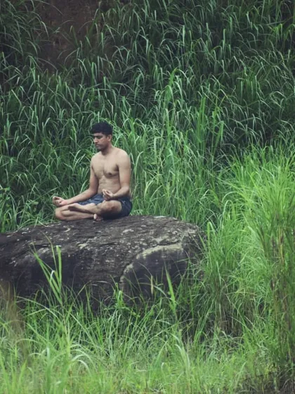 Finding strength in stillness. I believe true wellness comes from connecting with nature and your inner self. This is me in a seated meditation pose on a rock, a practice I teach to build mental focus and calm.
