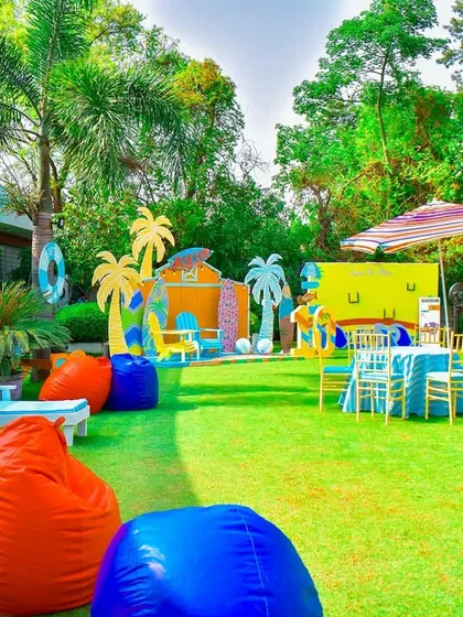 A vibrant summer pool party theme, with colorful bean bags, poolside lounge chairs, and a backdrop of surfboards and palm trees.