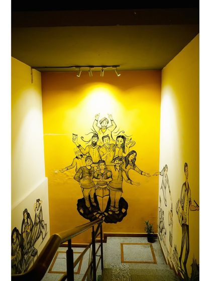 The vibrant mural on our staircase wall tells a story of community and connection. It's one of the many artistic touches that make my cafe unique.