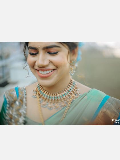A close-up of the bride's joyful smile, her beautiful jewelry and the vibrant colors of her outfit shining brightly.