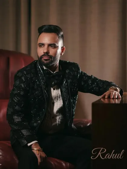 A classic, handsome portrait of the groom seated in a leather chair, looking away thoughtfully. This shot exudes confidence and style.